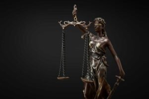 bronze-statuette-with-scales-of-justice-isolated-on-black.jpg